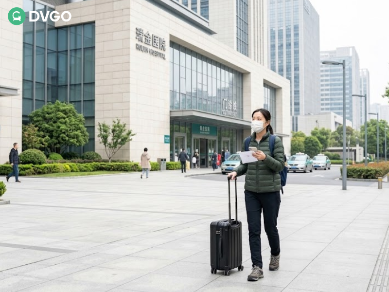 女子手拿行李箱走在现代化的医院/建筑前